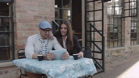 Young couple browsing the internet or online shopping in cafe. Steadicam shot Stockbeeldmateriaal 199632156