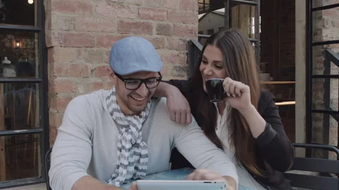 Young couple browsing the internet or online shopping in cafe. Steadicam shot Stockbeeldmateriaal 199632169