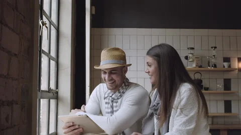 Young couple browsing the internet or online shopping in cafe. Steadicam shot Stock Footage 199632236
