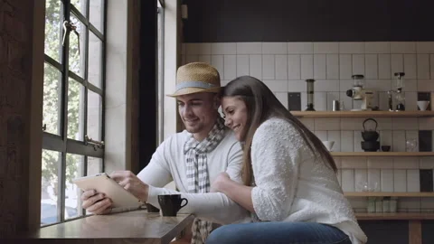 Young couple browsing the internet or online shopping in cafe. Steadicam shot Stock-Footage 199632272