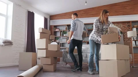 Young couple carrying boxes in new apartment on moving day.New accommodation or Stock Footage 170164385