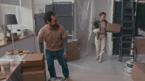 Young Couple Carrying Boxes while Entering Living Room during Relocation Stock Footage 302764944