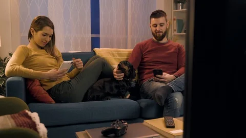 Young couple chatting with their mobile devices and ignoring each other Stock Footage 128727855
