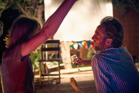 A young couple chatting while enjoying a night out in the bar at the river .. Stock Photos