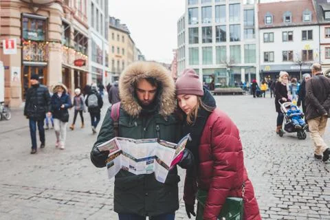 A young couple checking the map while walking in the downtown of Wurzburg, Ge Stock-Fotos
