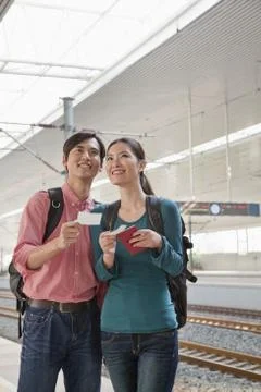 Young Couple Checking The Train Schedule Stock Photos