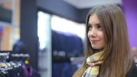 Young couple choose a jacket in the store. Loving guy and girl buy clothes in Stock Footage 75879951