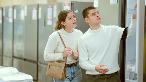 Young couple choosing a powerful refrigerator with a large freezer compartment Stock Footage 328138460