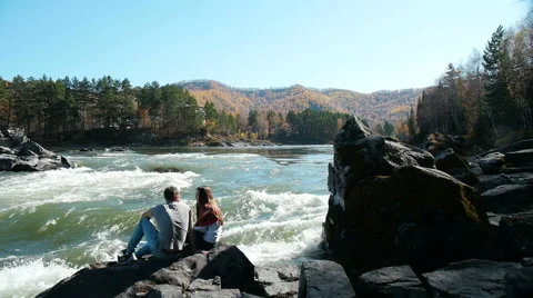 A young couple close to fast mountain river 스톡 동영상 60030389