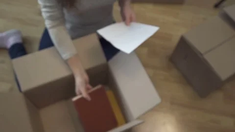 Young couple collects things in a box for moving to a new apartment Stock Footage 83481357