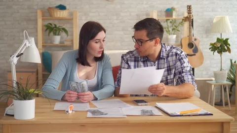 Young couple concerned and tense, doing the calculations documents with Stock-Footage 106598218