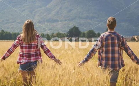 Young couple contemplate wheat field Stock Photos