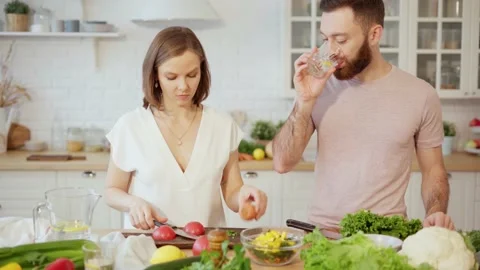 Young couple cooking together preparing dinner at home Stock Footage 146277261