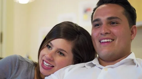 Young couple cuddles on couch 動画素材 64331876