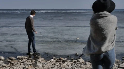 Young couple cuddling,in background a river covered with ice,sunny spring day Stock Footage 124427616
