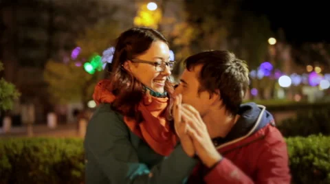 Young couple cuddling on date in night city. Attractive girl sitting on his lap Stock Footage 49244045