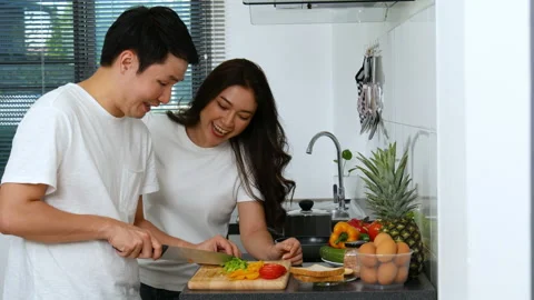 Young couple cutting vegetables for preparing healthy food in the kitchen Stock Footage 170709655