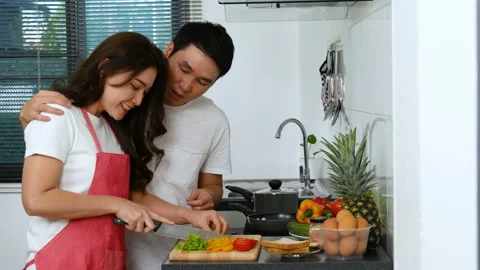 Young couple cutting vegetables for preparing healthy food in the kitchen Stock Footage 170709805