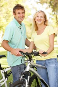 Young couple on cycle ride in park Stock Photos