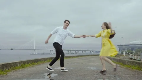 Young couple dance cheerfully some swift boogie on a pier on a sea coast Stock Footage 80199477