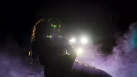 Young couple dance in a dark space with smoke. Slow motion. Silhouette Stock Footage 211807616