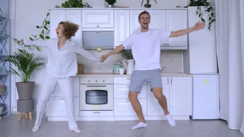 Young couple dances joyfully in kitchen positive emotions love dancing happiness Stock Footage 277723910