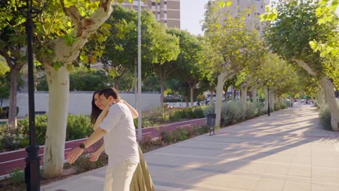 Young couple dancing and having fun in a city park Stock Footage 303854439
