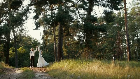 Young couple dancing on a hill in a forest in the sun Stock Footage 123588377