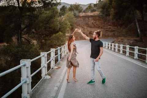 Young couple dancing in the middle of a road across a bridge Stock Photos