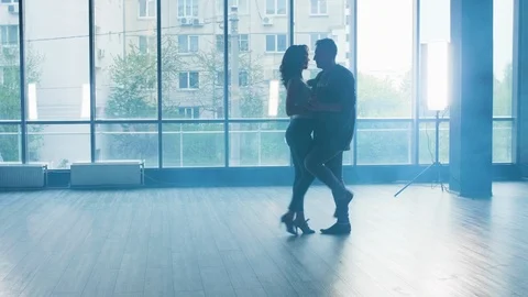 A young couple dancing with passion in a studio with smoke Stock Footage 107424493