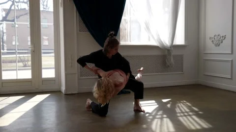 A young couple is dancing in a spacious, bright room. the guy is on knee, the Stock Footage 165932174