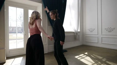 A young couple is dancing in a spacious, bright room. they stretch out arms and Stock Footage 166168554