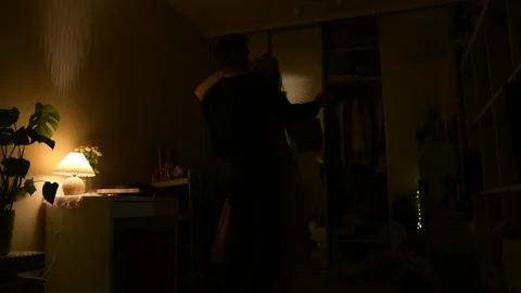 Young couple dancing together in a dimly lit room during the evening. 库存影片 330800651