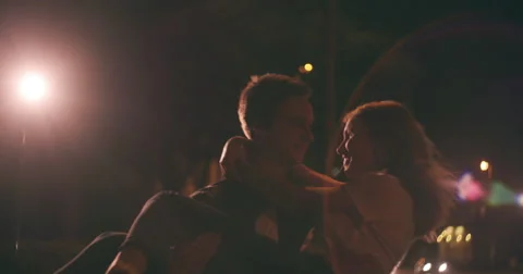 Young couple on a date at night on city street Stock Footage