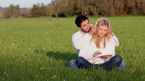Young couple with digital tablet an head phones Stock Footage 57727339