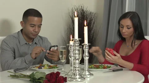 Young couple at dinner table with smartphones Stock Footage 44113733
