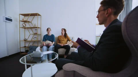 Young couple discussing problems during therapy session with psychologist Видео 339615891