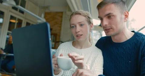 A young couple discussing something in the cafe at lunchtime Stock Footage 87863589