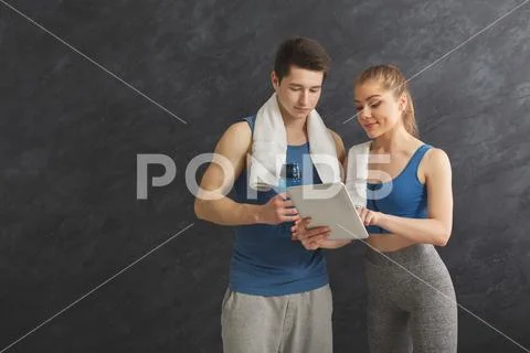 Young couple discussing workout plan at gym Stock Photos