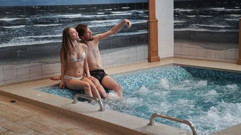 Young couple Do selfie posing are having fun in the swimming pool Jacuzzi Stock Footage 75502339