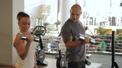 Young couple doing biceps dumbbells curls in gym indoors. Stock Footage 83152887