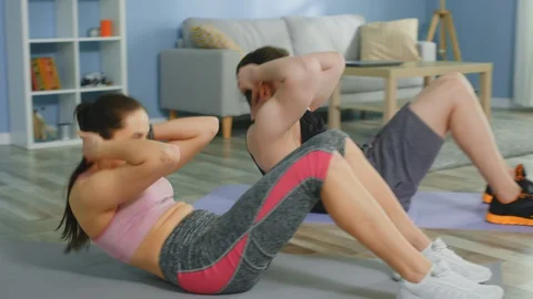 Young Couple Is Doing Crunches Together at Home Vídeo Stock 129743220