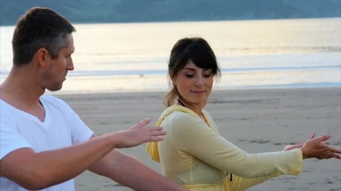 Young couple doing a hula on the beach together. Stock Footage 88406676