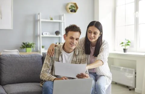 Young couple doing paperwork, using laptop, managing finances, paying taxes and Stock Photos