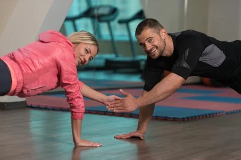 Young Couple Doing Push-Up Exercise In The Gym Foto stock