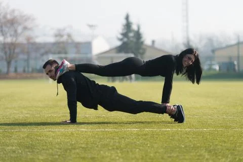 Young Couple Doing Push-up Exercise in the Park Stock Photos