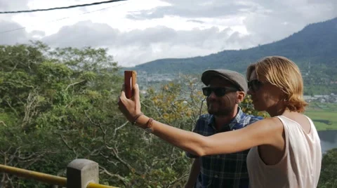 Young couple doing selfie on smart phone on the beautiful landscape background Stock Footage 68030443