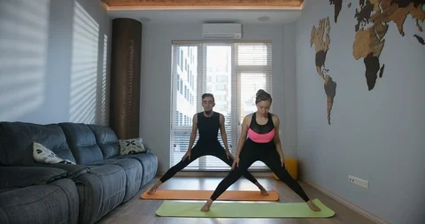 Young couple doing streching bending forward exercise. Full length portrait of Stock Footage 113408191