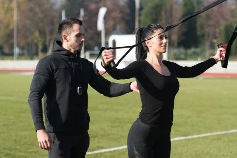 Young Couple Doing Trx Straps Exercise in Park Stock Photos