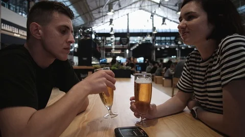 Young couple drinking bear and waiting for food in food market in Lisbon Video stock 128137791